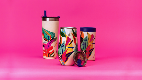 Colorful antimicrobial tumblers with floral designs on a pink background